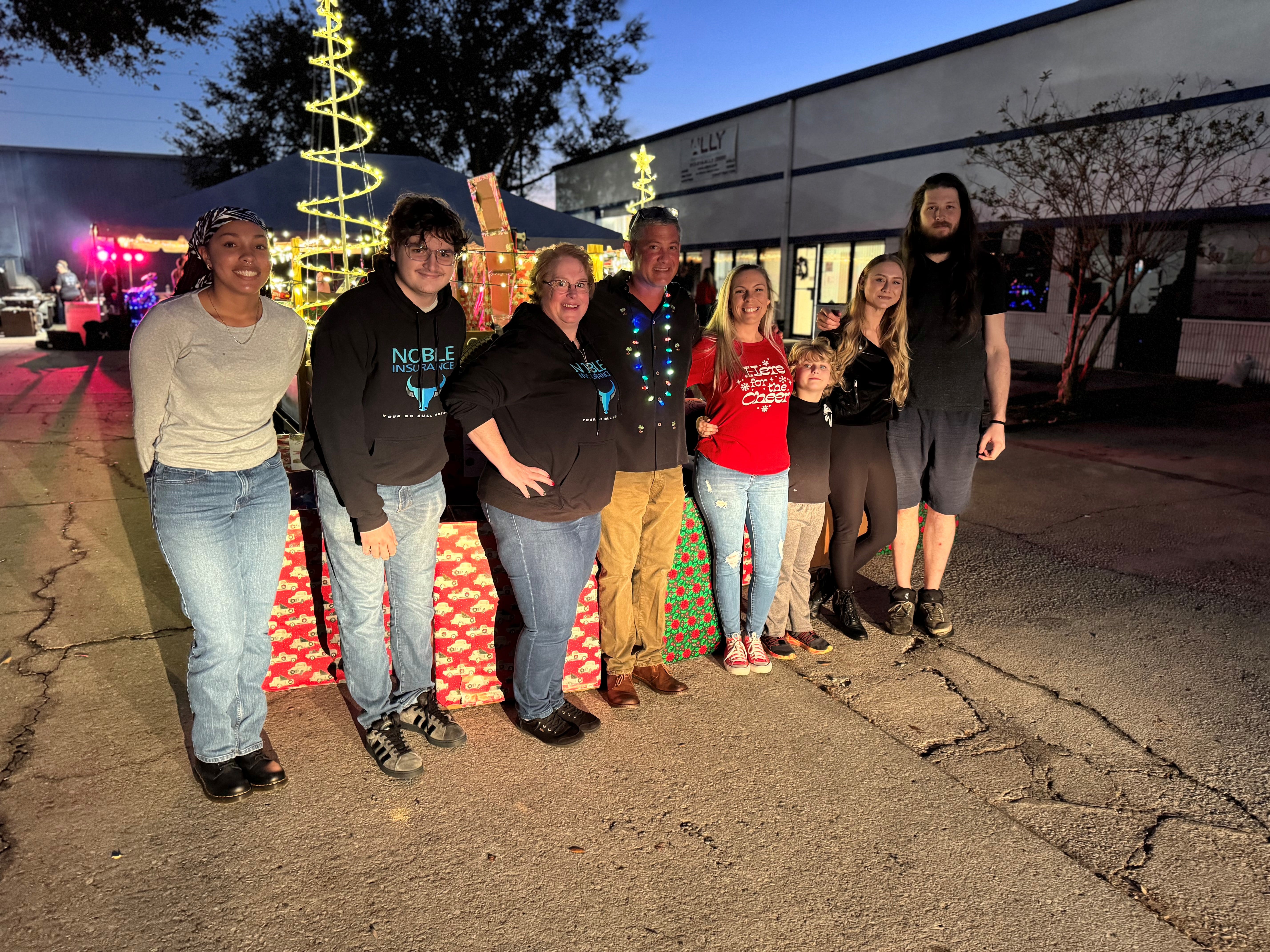 noble team and family together in front of  Christmas tree two